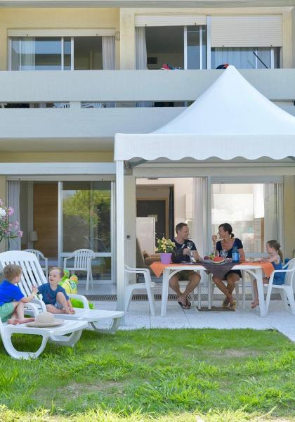 Familie isst im Freien unter einem Pavillon im Garten.