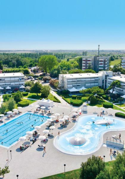 Complesso residenziale con piscine e giardini, immerso nel verde.