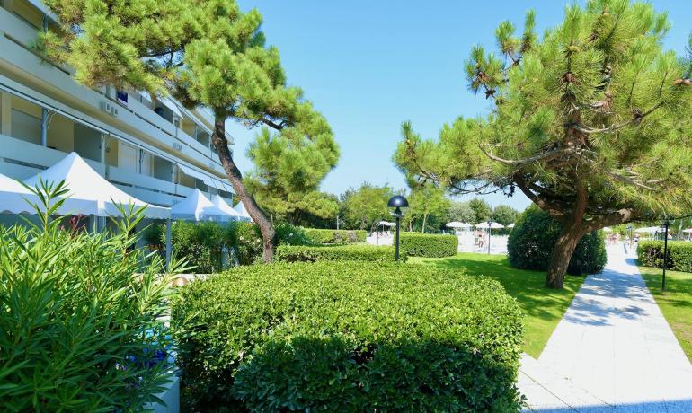 Giardino curato con alberi e sentiero vicino a un edificio.