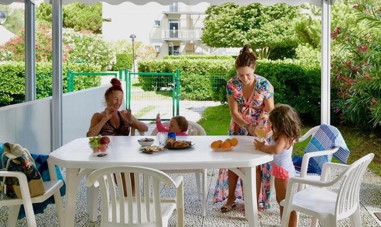 Family gathered outdoors for breakfast under a gazebo.