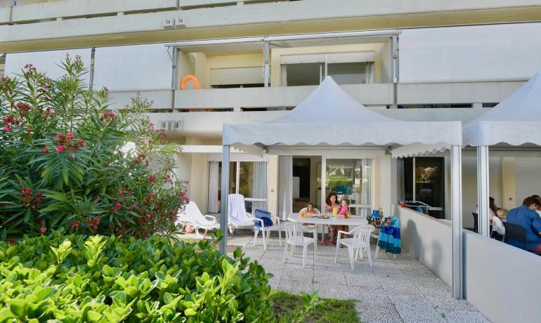 Family dining under a gazebo in the garden.